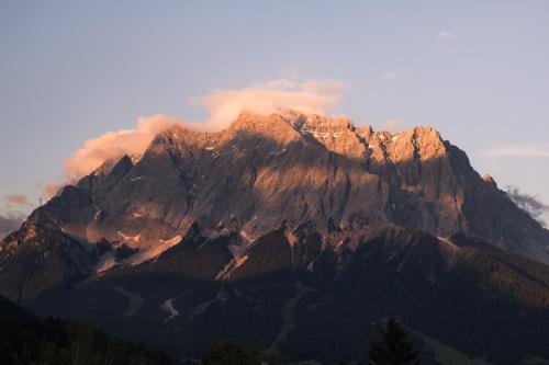 a large mountain with smoke coming out of it at Hotel Klockerhof in Lermoos