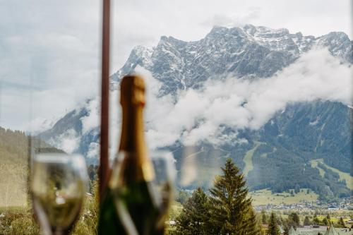 a glass of wine in front of a mountain at Hotel Klockerhof in Lermoos