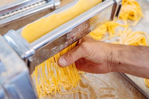 a hand is holding a bunch of pasta at Hotel Klockerhof in Lermoos