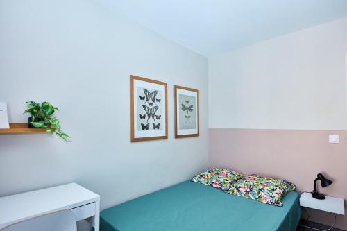 une chambre avec un lit bleu et deux tableaux au mur dans l'établissement Appartement T3 15min des plages, à Marseille
