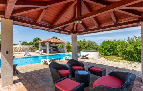 taras z krzesłami i basenem w obiekcie Villa With Pool, Jacuzzi, Sauna, Fitness, Playground & Wine Cellar w mieście Gostinjac