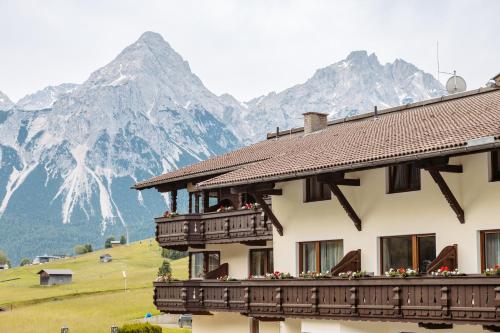 a building with a balcony with mountains in the background at Hotel Klockerhof in Lermoos