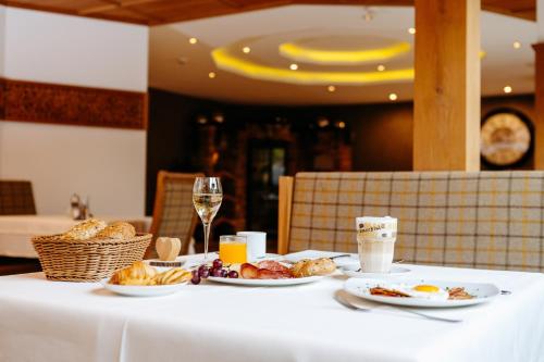 a table with plates of food and glasses of wine at Hotel Klockerhof in Lermoos
