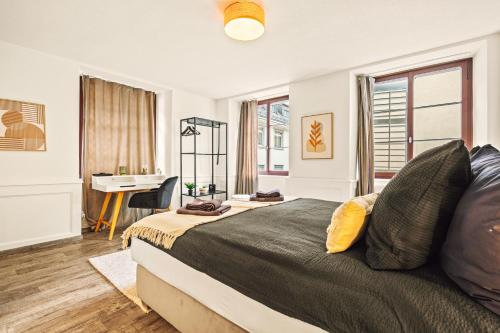 a bedroom with a large bed and a desk at A&Y LakeHouse Golden Swan in Luzern