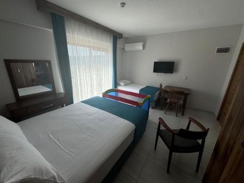 a bedroom with two beds and a chair and a table at Troilus Park House in Eceabat