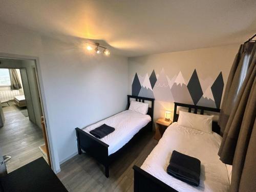 une chambre avec deux lits dans une pièce dans l'établissement Summer Alps Apartment, à Saint-Martin-de-Belleville