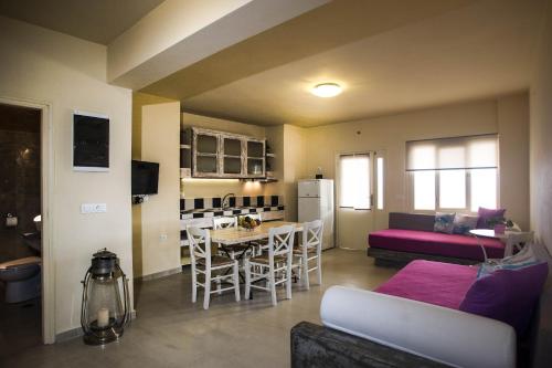 a kitchen and living room with a table and a couch at Drakkar Houses in Fira