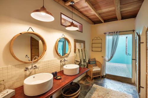 a bathroom with two sinks and a mirror at Chundukwa River Lodge - Self Catering House in Livingstone