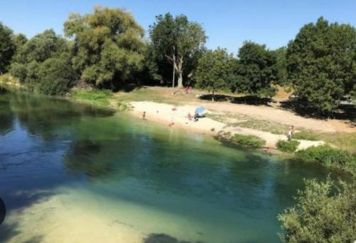 a group of people on a beach near a river at CHAMBRE et JARDIN Village au bord de l eau Cour et Garage privés in Marcilly-sur-Seine