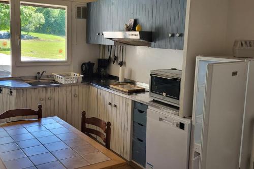 Il comprend une cuisine équipée d'un réfrigérateur et d'une table avec un four micro-ondes. dans l'établissement Logement saisonnier la bourboule, à La Bourboule