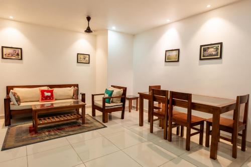 a living room with tables and chairs and a couch at Borail Homes in Silchar