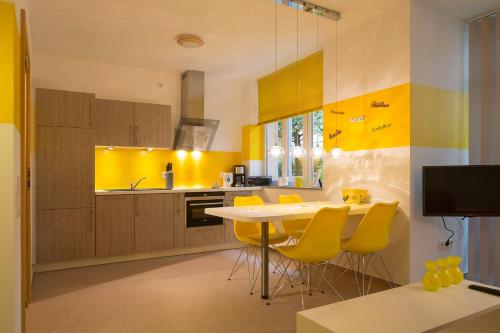 a kitchen with yellow walls and a table with yellow chairs at Jovles Beisken GmbH in Münster