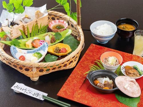 a table with a basket of food and chopsticks at 蔵王温泉 岩清水料理の宿 季の里 in Zao Onsen