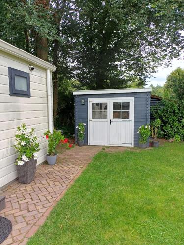 a small shed with a door in a yard at De Woudtplaats in Wolfheze