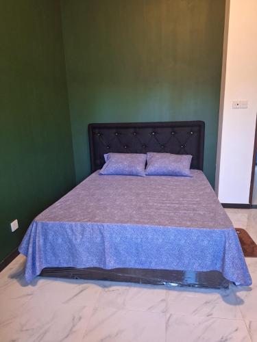 a bedroom with a bed with a purple bedspread at Royal Villa in Marawila