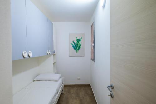 Habitación blanca pequeña con cama y puerta en Baron’s Suites, en Palermo