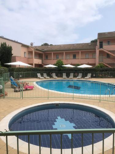 une grande piscine avec des chaises et un bâtiment dans l'établissement Bravone, à Linguizzetta