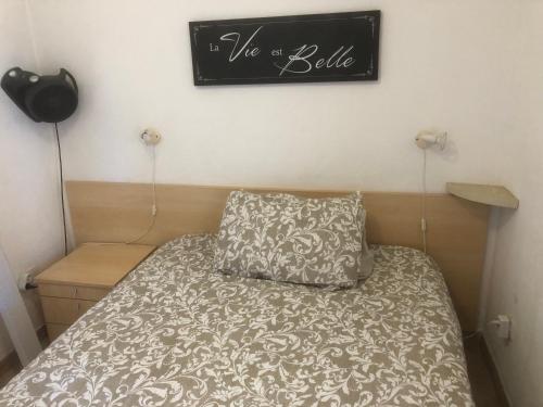 - un lit avec un oreiller et une pancarte murale dans l'établissement Bravone, à Linguizzetta