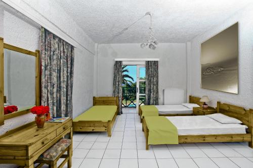 a hotel room with two beds and a balcony at Classic Apartments in Hersonissos