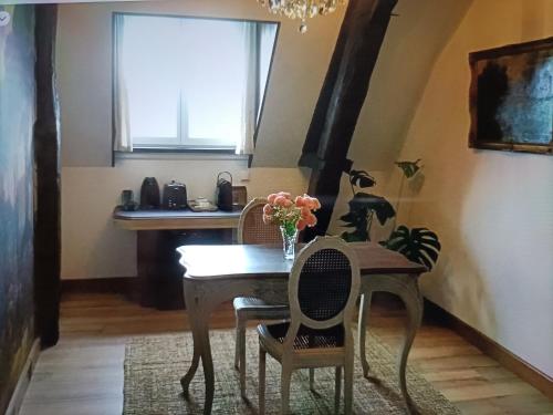 a dining room with a table and chairs and a window at Au cœur des prés in Montmort
