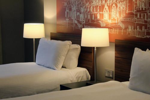 a hotel room with two beds and two lamps at The Townhouse Manchester in Manchester