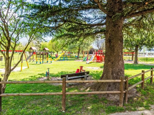 a park with a tree and a bench and a playground at Apartment Pippo by Interhome in Masina