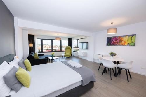 a bedroom with a large bed and a living room at Lounge 8 Studios in Oradea