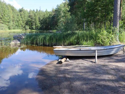 um pequeno barco sentado na margem de um lago em Holiday Home Unnukkamaja by Interhome em Leppävirta