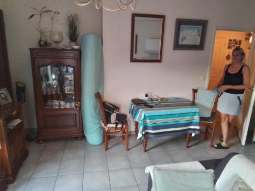 une femme debout dans une pièce avec une table dans l'établissement Studio Biarritz, à Biarritz