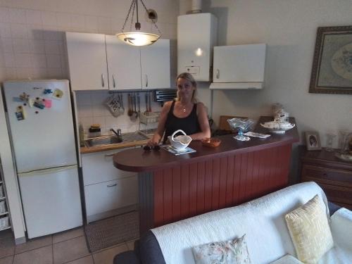une femme debout à un comptoir de cuisine avec un réfrigérateur dans l'établissement Studio Biarritz, à Biarritz