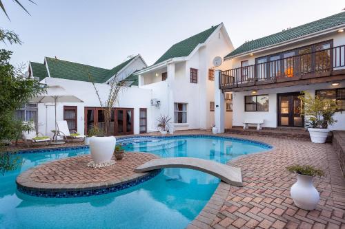 a swimming pool in front of a house at A White House Guest House in Grahamstown