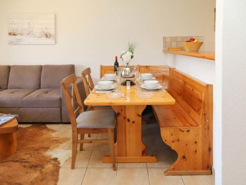 a wooden dining room table with chairs and a couch at Apartment Cascades d'Eden 2 by Interhome in Crans-Montana