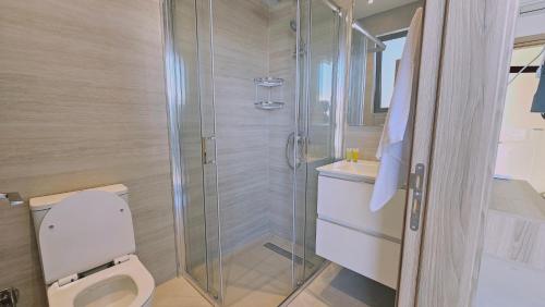 a bathroom with a toilet and a glass shower at STAY Oasis Luxury Villas in Ayia Napa