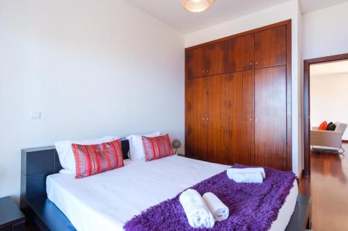 a bedroom with a large bed with two towels at GuestReady - Spacious stay with sea views in Caniço