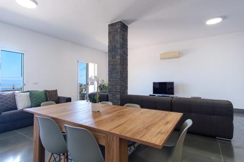 a dining room with a wooden table and a couch at GuestReady - Spacious stay with sea views in Caniço