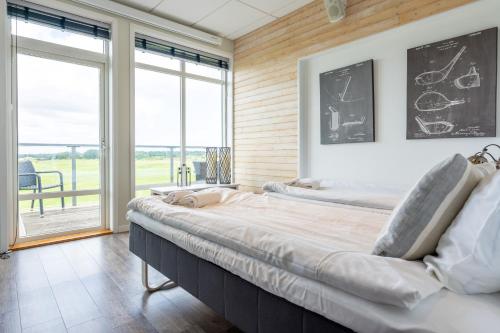 a bedroom with two beds and a large window at Halmstad Golfarena Hotell & Lägenheter in Halmstad