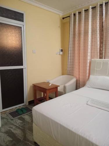 a bedroom with a bed and a tub and a table at Secret hotel in Dar es Salaam