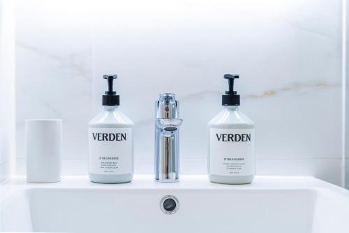 a group of three bottles sitting on a bathroom sink at Cozy 2 Bedroom Apartment in Sutton in Sutton