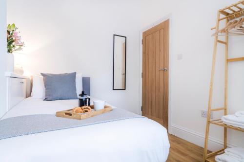 a bedroom with a bed with a tray of bread on it at Cozy 2 Bedroom Apartment in Sutton in Sutton