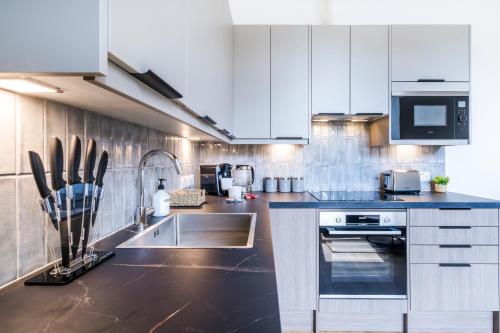 a kitchen with a sink and a stove top oven at Cozy 2 Bedroom Apartment in Sutton in Sutton