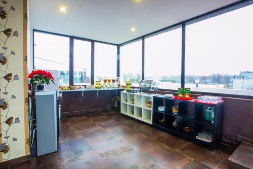 a restaurant with a counter and some windows at Hotel Charter Otopeni in Otopeni