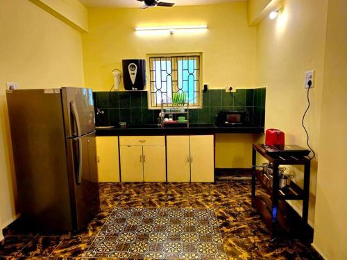 a kitchen with a stainless steel refrigerator and a window at Casa de Bella in Candolim