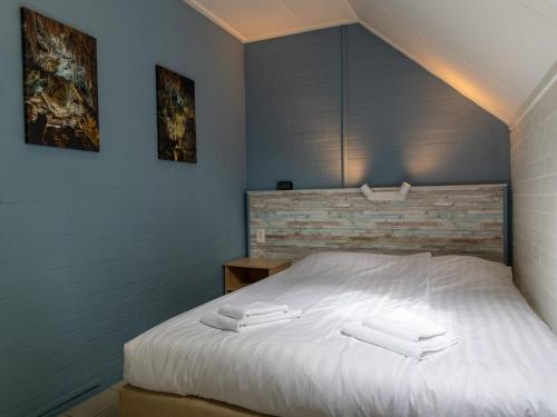 a bedroom with a bed with two white towels on it at Holiday Home Buitenplaats Gerner-5 by Interhome in Dalfsen