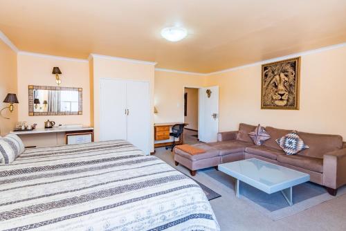 a large bedroom with a bed and a couch at Ipe Tombe Guest Lodge - Midrand in Midrand