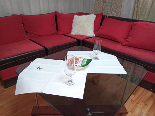 a couch and two wine glasses on a table at La gura sobei in Mărăcineni