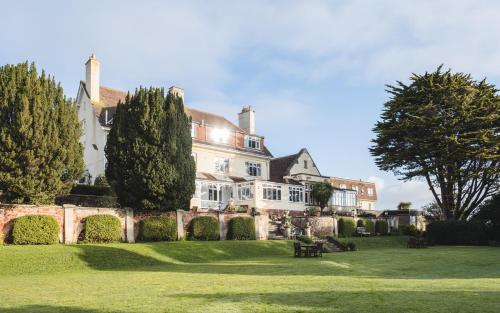a large white house with trees in the yard at Northfield Hotel in Minehead
