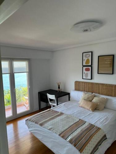 a bedroom with a bed and a desk and a window at PIPER ETXEA. Relax, mar y monte! in Mutriku