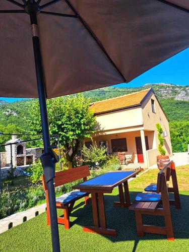 a picnic table and bench under an umbrella at Aria in Cetinje