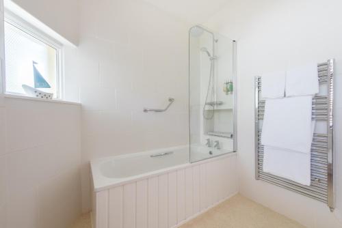 a white bathroom with a shower and a window at Northfield Hotel in Minehead