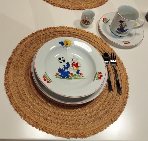 a table with plates and utensils on a white table at Portokalia in Mystras